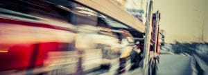 Blurred motion shot of auto transporter truck on highway symbolizing fast and efficient vehicle delivery