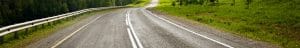 Scenic open road winding through green countryside representing vehicle transport routes by Open Road Carriers