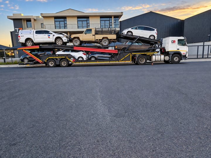 Open Road Carriers — a covered trailer and vehicles.