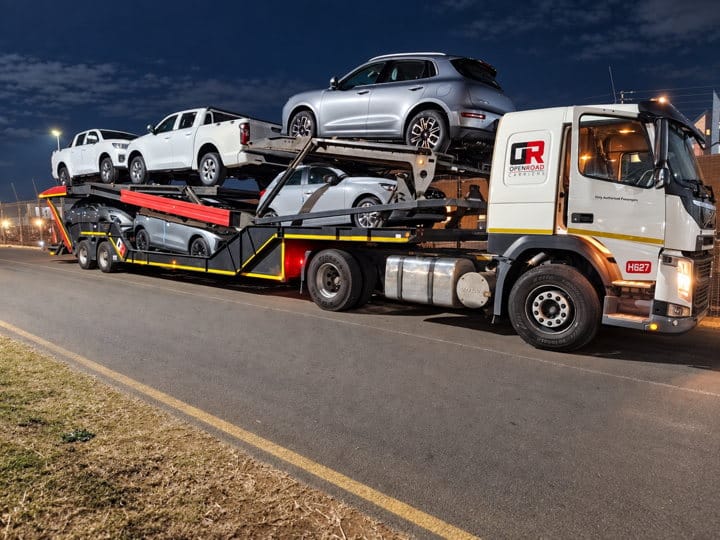 Open Road Carriers — a loaded transporter at dusk.