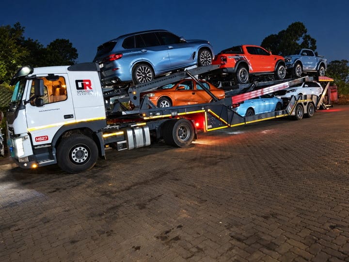 Open Road Carriers — cars on a carrier at night.